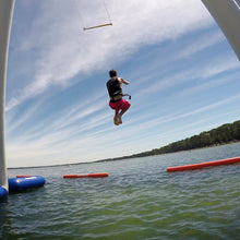 Person wakeboarding on a lake with a clear sky and trees in the background